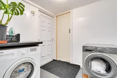 a laundry room with a washer and dryer at The Old Bike Shop Flat 2 in Heapey