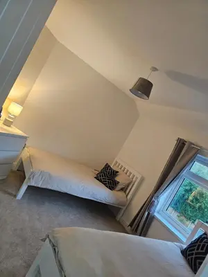 a attic room with two beds and a window at Luxe Residences - Preston in Preston