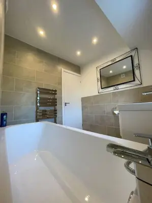a bathroom with a large white tub and a sink at Luxe Residences - Preston in Preston