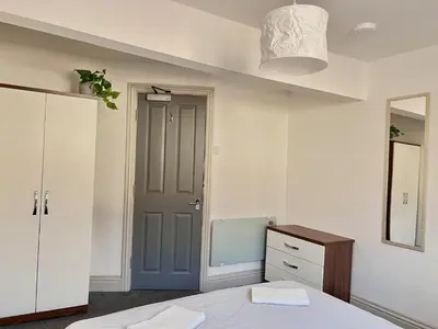 a bedroom with a bed and a cabinet and a mirror at Apartment 6 in Blackpool