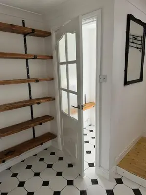a room with a door and a black and white floor at Sunshine cottage in Horwich
