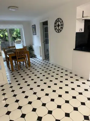 a kitchen with a black and white tiled floor at Sunshine cottage in Horwich