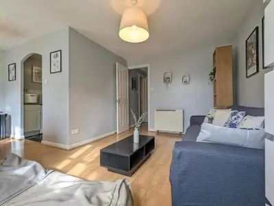 a living room with a blue couch and a table at City Centre Vintage Theme Guest Rooms in Liverpool