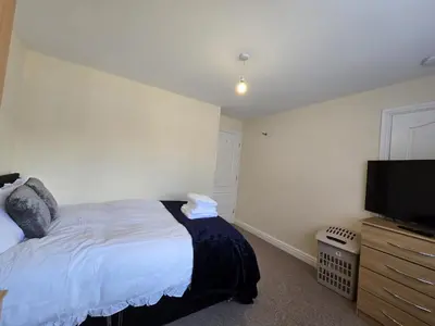 a bedroom with a bed and a flat screen tv at A Classic Home in Liverpool in Liverpool