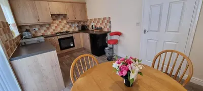 a kitchen with a table with a vase of flowers on it at A Classic Home in Liverpool in Liverpool