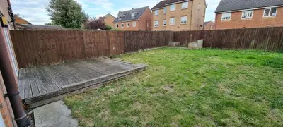 a backyard with a wooden fence and a grass yard at A Classic Home in Liverpool in Liverpool