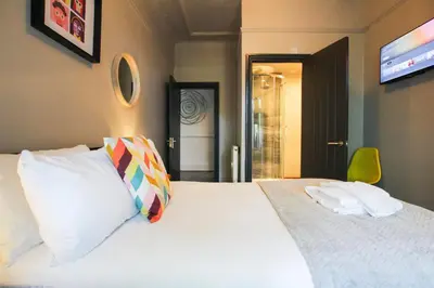 a bedroom with a large white bed and a television at Parkside View Wallasey 5 bedroom 5 bathroom with on-street parking ideal for Groups Families or Contractors with vans by Rework Accommodation in Wallasey