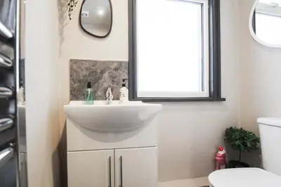 a bathroom with a sink and a mirror at Parkside View Wallasey 5 bedroom 5 bathroom with on-street parking ideal for Groups Families or Contractors with vans by Rework Accommodation in Wallasey