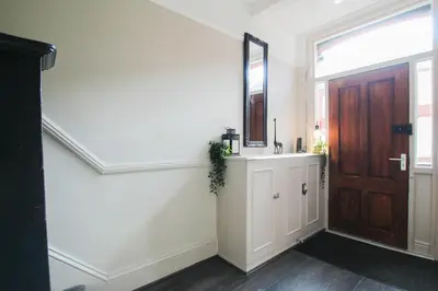a hallway with a wooden door and a mirror at Parkside View Wallasey 5 bedroom 5 bathroom with on-street parking ideal for Groups Families or Contractors with vans by Rework Accommodation in Wallasey