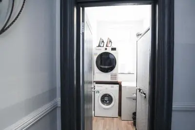 a laundry room with a washer and dryer in it at Parkside View Wallasey 5 bedroom 5 bathroom with on-street parking ideal for Groups Families or Contractors with vans by Rework Accommodation in Wallasey