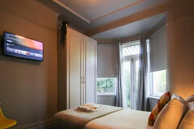 a bedroom with a bed and a tv on the wall at Parkside View Wallasey 5 bedroom 5 bathroom with on-street parking ideal for Groups Families or Contractors with vans by Rework Accommodation in Wallasey