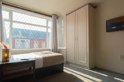 a bedroom with a bed and a large window at Parkside View Wallasey 5 bedroom 5 bathroom with on-street parking ideal for Groups Families or Contractors with vans by Rework Accommodation in Wallasey