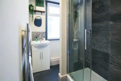 a bathroom with a shower and a sink at Parkside View Wallasey 5 bedroom 5 bathroom with on-street parking ideal for Groups Families or Contractors with vans by Rework Accommodation in Wallasey