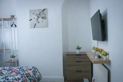 a bedroom with a dresser and a tv on the wall at Anfield Walk in Liverpool