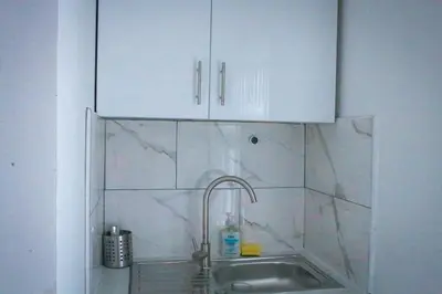 a kitchen with a sink and white cabinets at Anfield Walk in Liverpool