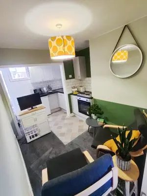 a living room with a couch and chairs and a kitchen at The Old Bike Cabin Flat 1 in Heapey
