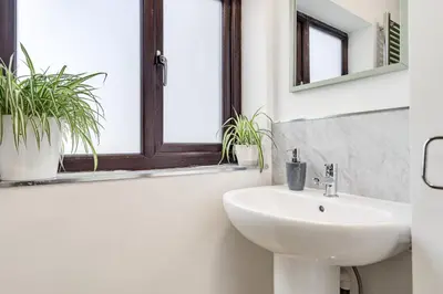 a bathroom with a sink and two potted plants at The Old Bike Cabin Flat 1 in Heapey