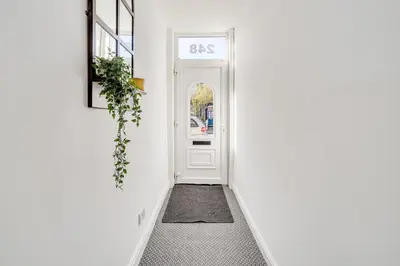 a hallway with a white door and a rug at The Old Bike Cabin Flat 1 in Heapey