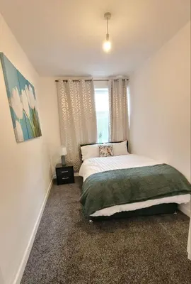a bedroom with a large bed and a window at Accrington - House - Sleeps 10 - Garden in Accrington