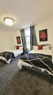a bedroom with two beds and a window at Accrington - House - Sleeps 10 - Garden in Accrington