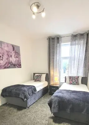 a bedroom with two beds and a window at Accrington - House - Sleeps 10 - Garden in Accrington