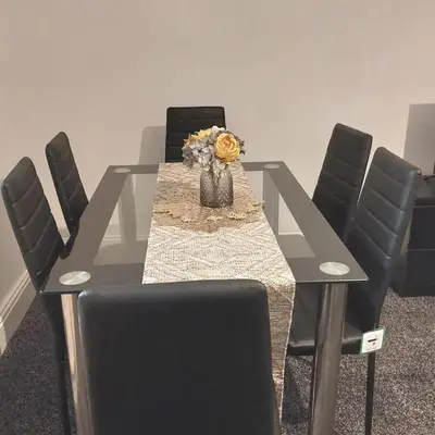 a dining room table with chairs and a vase of flowers at Accrington - House - Sleeps 10 - Garden in Accrington