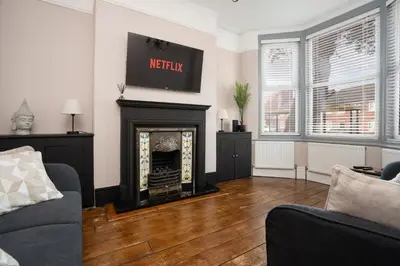 a living room with a fireplace and a tv at Swiss Haven - Spacious 3 Bedroom House in Liverpool