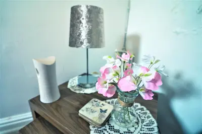 a table with a vase of flowers and a lamp at Travellers Stays In The Heart Of Orrell Park in Liverpool