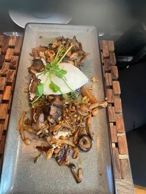 a plate of food with mushrooms on a table at The Rooms Lytham in Lytham St Annes