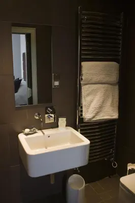 a bathroom with a white sink and a mirror at The Rooms Lytham in Lytham St Annes