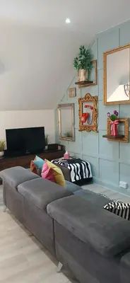 a living room with a couch with pillows on it at Seaside Apartment in Moreton