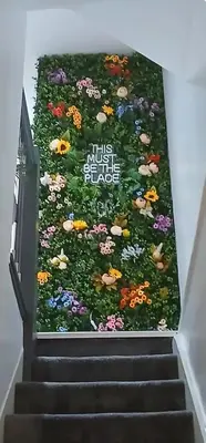 a wall of flowers on the stairs of a building at Seaside Apartment in Moreton