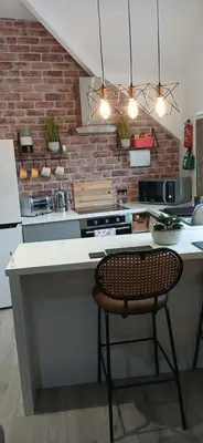 a kitchen with a counter with a chair in it at Seaside Apartment in Moreton