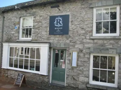 a stone building with a green door and windows at 2 Bed Cottage in Peaceful South Lakes Village in Cark