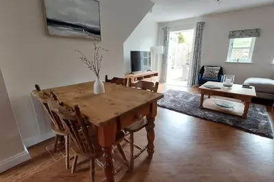 a living room with a table and a couch at 2 Bed Cottage in Peaceful South Lakes Village in Cark