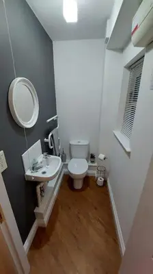 a bathroom with a toilet and a sink and a mirror at 2 Bed Cottage in Peaceful South Lakes Village in Cark