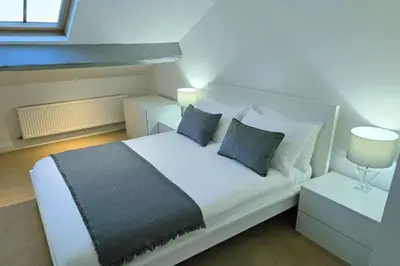 a bedroom with a white bed with two night stands and lamps at Stylish City Centre Apartment with Parking in Preston