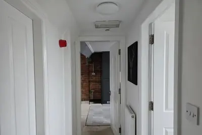 a hallway leading to a room with a brick wall at Stylish City Centre Apartment with Parking in Preston