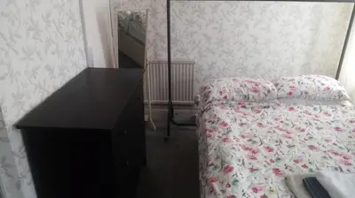 a bedroom with a bed with a dresser and a mirror at The New Macleods Guest House in Blackpool