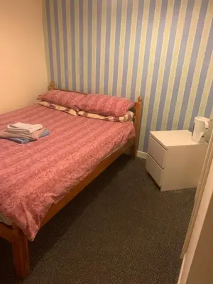 a small bedroom with a bed and a night stand at The New Macleods Guest House in Blackpool