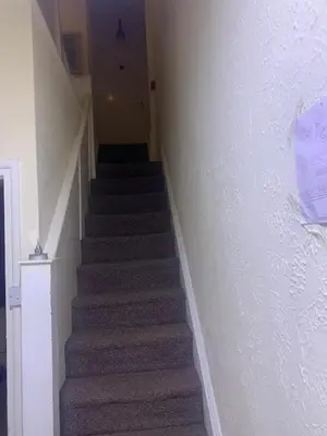 a hallway with stairs with a sign on the wall at The New Macleods Guest House in Blackpool