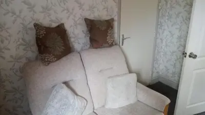 a living room with a white couch and pillows at The New Macleods Guest House in Blackpool