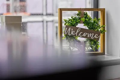 a picture with the word welcome next to a plant at Baltic Triangle Apartment in Liverpool