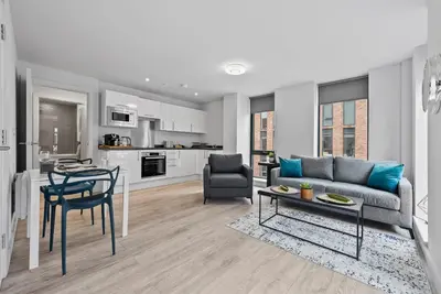 a living room with a couch and a table at Baltic Triangle Apartment in Liverpool