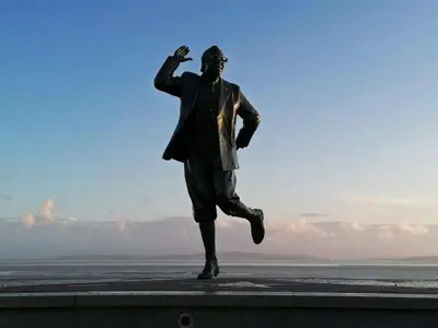 a statue of a man running on a ledge at Mags den in Morecambe