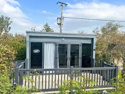 a small house with a porch with a fence at The Lodge Pod in Barrow in Furness
