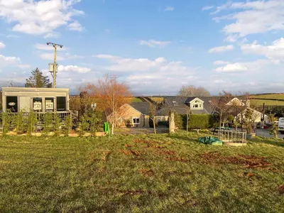 a house in a field with a yard at The Lodge Pod in Barrow in Furness