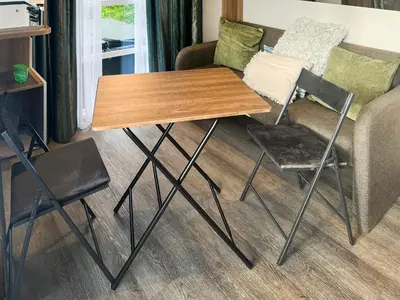 a wooden table and two chairs and a couch at The Lodge Pod in Barrow in Furness