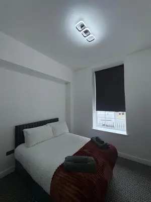 a bedroom with a bed and a large window at 38 Everton Road Free onsite parking in Liverpool