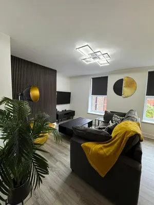 a living room with a black couch and a plant at 38 Everton Road Free onsite parking in Liverpool